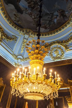 Geniş bir odanın tavanında zarif bir şekilde asılı duran büyük ve güzel tasarlanmış bir avize, cazibe ve ışık katıyor.