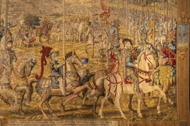 Bu sanat eseri, bir grup adamın geniş ve açık alanda ustalıkla ata bindiği canlı ve dinamik bir sahneyi tasvir ediyor.