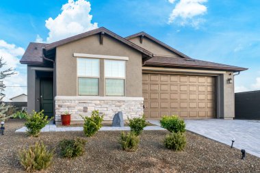 Geniş, geniş bir garaj kapısı ve bolca pencerenin olduğu bir ev. İçeriye bolca ışık giriyor.