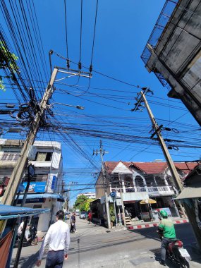 Bir sokak üzerinde bir grup elektrik hattı asılıdır, şehir manzarasına eklenir ve yerel elektrik ağını etkiler