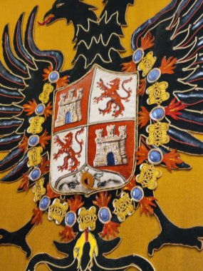 Bu, çok güzel tasarlanmış bir armanın ayrıntılı bir tasviri. Canlı sarı bir arka plana karşı dizilmiş. Karmaşık sanatlar sergiliyor.