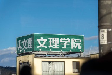 Fujiyama, Japonya - 2 Ocak 2025: Japonya 'da güzel bir gökyüzü zemininin altında yer alan bir okulun adını belirgin bir şekilde gösteren son derece dikkat çekici bir tabela