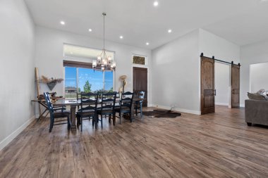 Geniş oturma odasının ortasında çok güzel bir yemek masası ve etrafında birkaç rahat sandalye var.