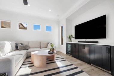 Rahat bir kanepe, şık bir masa ve boş zamanlarınızda eğlenmek için geniş bir televizyon olan rahat bir oturma odası.