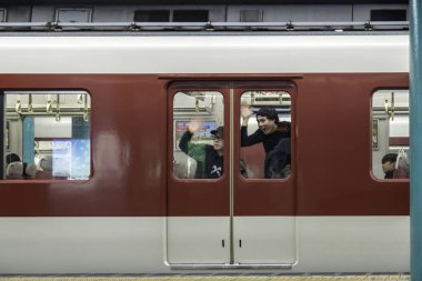 Kyoto, Japonya - 27 Aralık 2024: Gezginler, hareketli bir Japon istasyonundan hareketli bir öğleden sonra ayrılırken el sallıyorlar. Yüksek kalite fotoğraf