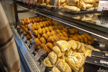 Büyüleyici bir pastanede, herkesi içeri davet eden çeşitli lezzetli yiyeceklerle dolu güzel bir vitrin var.