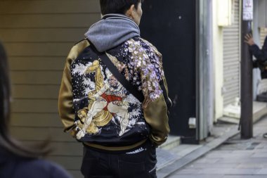 Kyoto, Japonya - 27 Aralık 2024: Japonya 'da yoldan geçen biri olarak kültür kavşağında hareketli bir şehir ortamında canlı bir ceket sergileniyor. Yüksek kalite fotoğraf