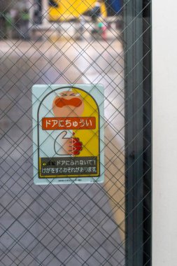 Tokyo, Japonya - 3 Ocak 2025: Yoğun bir Japon kentsel ortamında bir kapıda emsalsiz tasarım unsurları gösteren güvenlik önlemleri bildirimi. Yüksek kalite fotoğraf