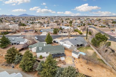 Bu görüntü, ağaçlarla çevrili çeşitli evleri gösteren ilginç ve büyüleyici bir hava manzarası sunuyor.