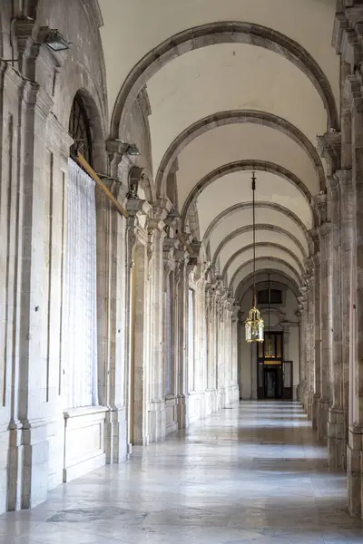 Uzun bir koridor, büyük bir bina tasarımı boyunca birden fazla kemer ve sağlam sütunlarla süslenmiş.