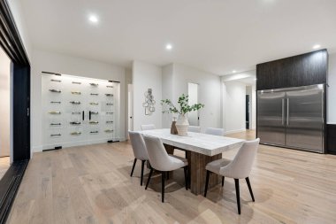 Güzel bir masa, rahat sandalyeler ve yiyecek ve içecek depolamak için bir buzdolabı olan rahat bir yemek odası.