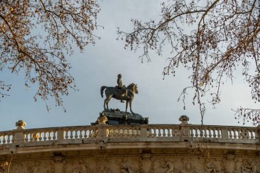 Bir köprünün üstünde gururla duran görkemli bir ata binen ve sanatsal sanatını sergileyen bir adamı tasvir eden olağanüstü bir heykel.