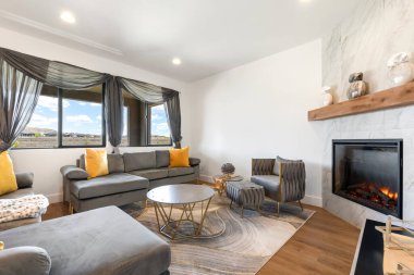 Konforlu oturma odası çeşitli mobilyalarla dolu ve rahatlatıcı bir ortam için sıcak, davetkar bir şömine.