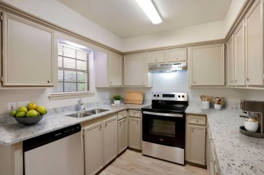 Zarif paslanmaz çelik aletlerle dolu modern bir mutfak. Temiz ve parlak bir estetik olan güzel beyaz dolaplarla birleştirilmiş.