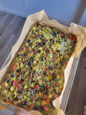 Bir insan, canlı sebzelerle dolu büyük bir tavayı ustalıkla tutarak renkli ve sağlıklı bir yemek yaratıyor.