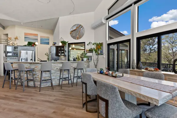 İçinde birkaç sandalye bulunan bir yemek masasının bulunduğu geniş bir oda, rahat bir yemek atmosferi yaratıyor.