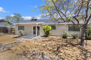 Bu güzel beyaz sarayda büyüleyici bir veranda ve önünde zarif bir şekilde duran bir ağaç sergileniyor.