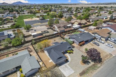 Büyüleyici bir ev, önünde geniş bir garaj yolu ve çekici bir çitin bulunduğu sakin bir yerleşim alanına yerleştirilmiştir.