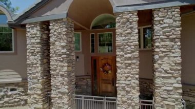 Havadan ve önden bakıldığında göz kamaştırıcı bir ev keşfedin. Bu konutta taş sütunlar, büyüleyici bir kapı ve kiremit çatılı taş bir veranda var.