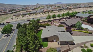 Geniş bir garaj yolu olan güzel bir ev ve önünde zarif bir şekilde duran birkaç ağaç, doğal gölgeler sunuyor ve manzarayı güzelleştiriyor.