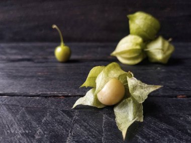 Physalis angulata veya siyah ahşap masada altın çilek. 