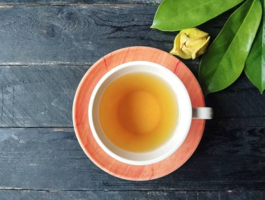 Kaynak yaprağı, ahşap masanın üzerinde cam içinde su kaynattı. Üst açı ayarlı.