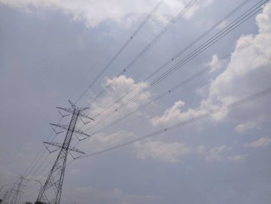 Yüksek voltajlı elektrik kulesi berrak gökyüzü ve alçak açılı bulutlar. 