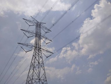 Yüksek voltajlı elektrik kulesi berrak gökyüzü ve alçak açılı bulutlar. 