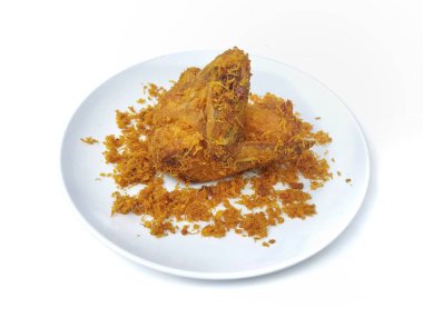 Ayam goreng serundeng ya da kızarmış tavuk ve kızarmış hindistan cevizi beyaz arka planda izole edilmiş tabakta.