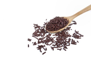 Beyaz arka planda izole edilmiş tahta kaşıkta çikolata parçaları. 