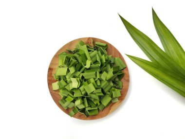 Taze pandan, beyaz arka planda izole edilmiş ahşap tabakta kesikler bırakır. 