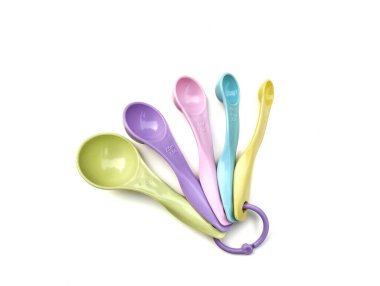 Beyaz arkaplanda izole edilmiş renkli plastik ölçüm kaşığı, yüksek açı görünümü