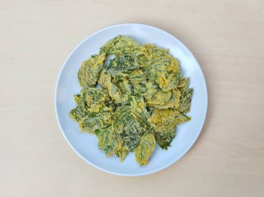 Ispanak cipsleri ıspanak yapraklarından yapılır ve beyaz tabakta baharatlı un kullanılarak kızartılır. 