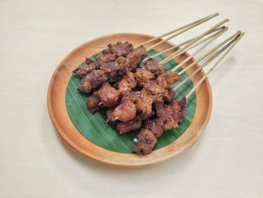 Satay ya da sate, Endonezya baharatlı şiş ve ızgara eti ahşap tabakta sosla servis edilir, yüksek açı manzaralı. 