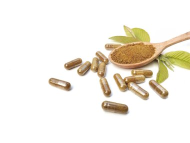 Alternatif tıp bitkisel kapsülleri ve beyaz arka planda izole edilmiş ahşap kaşık, yüksek açı görünümü 