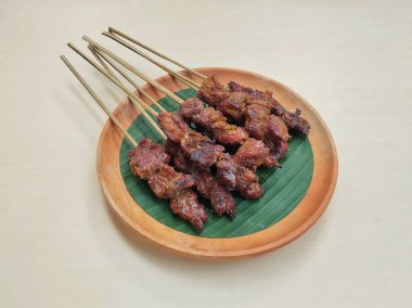 Satay ya da sate, Endonezya baharatlı şiş ve ızgara eti ahşap tabakta sosla servis edilir, yüksek açı manzaralı.