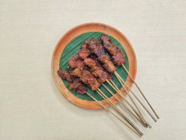 Satay ya da sate, Endonezya baharatlı şiş ve ızgara eti ahşap tabakta sosla servis edilir. 