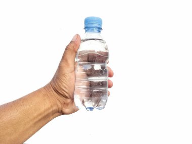 Beyaz arka planda izole edilmiş bir şişe maden suyu tutan bir adam. 