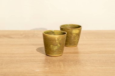 Ahşap bir masada el yapımı seramik. Beyaz duvar arka planı. ürün fotoğrafçılığı.