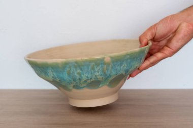 Bir el salata kasesini ahşap tezgahın üzerinde tutar. Yüksek kalite fotoğraf