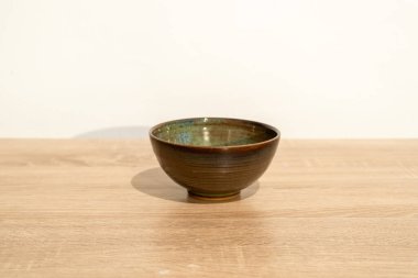 Ahşap bir masada el yapımı seramik. Beyaz duvar arka planı. ürün fotoğrafçılığı.