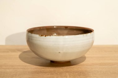 Tahta bir masada seramik bir salata kasesi. Yüksek kalite. Ürün fotoğrafçılığı. Beyaz duvar arkaplanı.