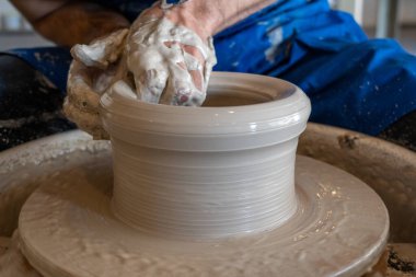 Potter stüdyoda bir tencereyi tekere fırlatıyor. Yüksek kalite fotoğraf. Hobi, ek iş, aktivite