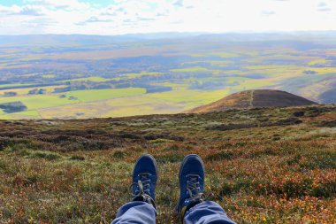 Adam parkta yürüyüş yaparken botlarının içinde dinleniyor. Yüksek kalite fotoğraf