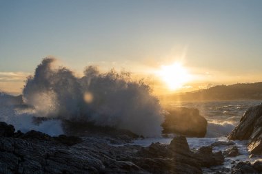 Gün batımında dalgalar kayalıklara çarpıyor. Yüksek kalite fotoğraf