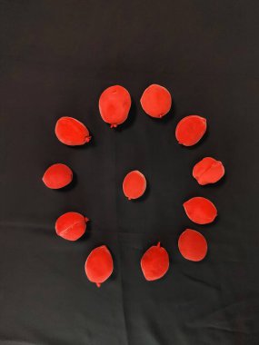 Birkaç şekerli kırmızı şeftali koyu bir arkaplanda daire oluşturur.