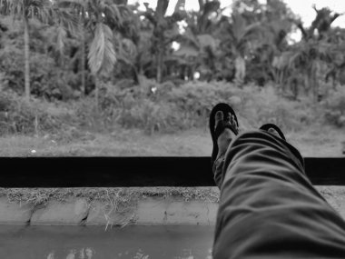 Santi's feet on a wooden block with a natural background clipart