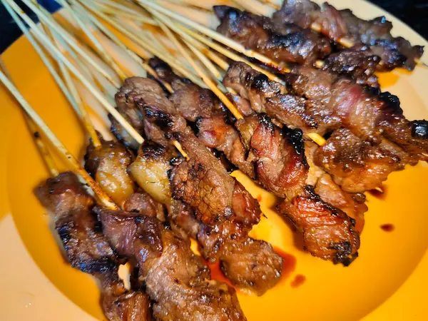 Bir sürü sığır şişini bir tabakta bir sürü et şişi ile kapatıyoruz.