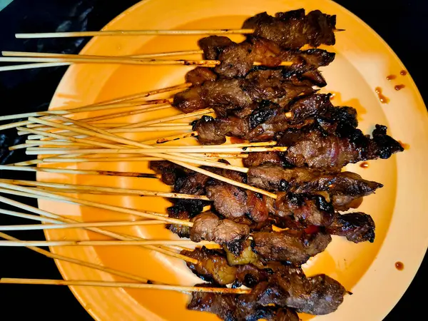 Bir sürü sığır şişini bir tabakta bir sürü et şişi ile kapatıyoruz.