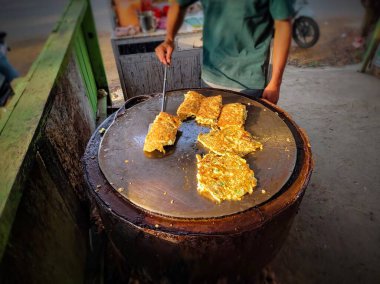 Sokak yemekleri, yumurta martabak satıcı düz tavada martabak pişiriyor.